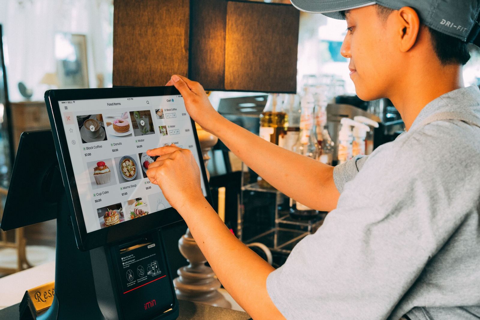 A waiter entering an order on the POS terminal
